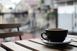 black ceramic teacup on brown wooden table