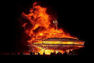 round building structure burning photo taken during nighttime HD wallpaper