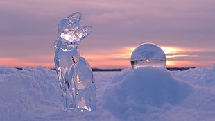clear glass cat figurine on snow