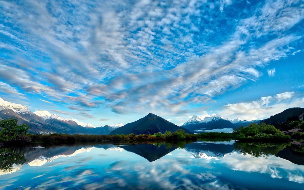 mountain near body of water under white cloud blue skies HD wallpaper