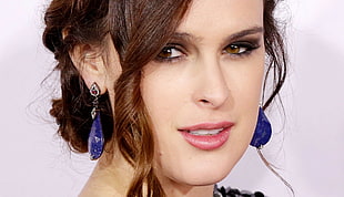 woman wearing blue pendant earrings smiling