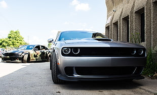 silver Dodge Challenger parked beside gray concrete building HD wallpaper