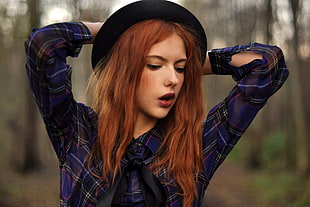 woman wearing blue and black plaid sport shirt with black hat during daytime
