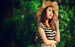 woman in brown and black stripe shirt and brown straw hat