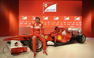 man in red overall suit with Ferrari F1 racing car HD wallpaper