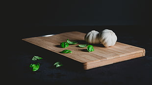 white garlic on brown wooden chopping board