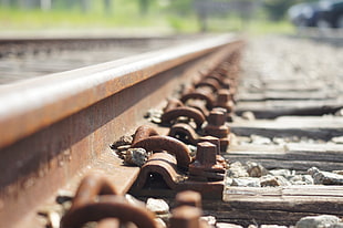 macro photography of brown steel train railway