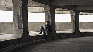 man sitting on concrete block