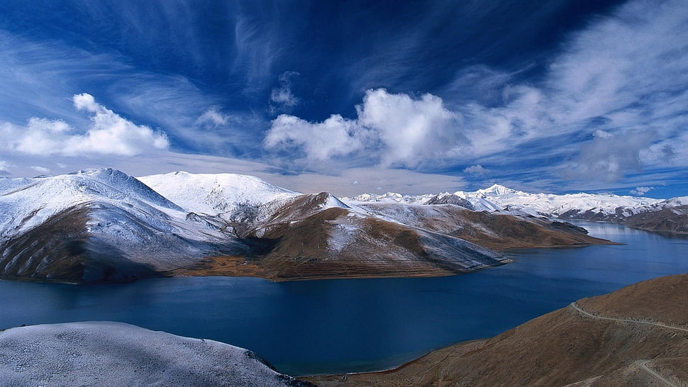 snow covered mountain near river under cloudy sky at daytime HD wallpaper