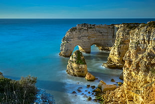 aerial view of rock formation and cliff beside blue ocean, algarve