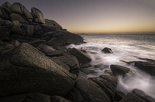 rocks near the seashore during golden hour
