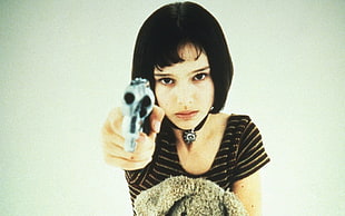 woman holding gray revolver