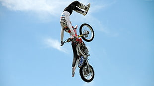 man riding motocross doing tricks in mid air