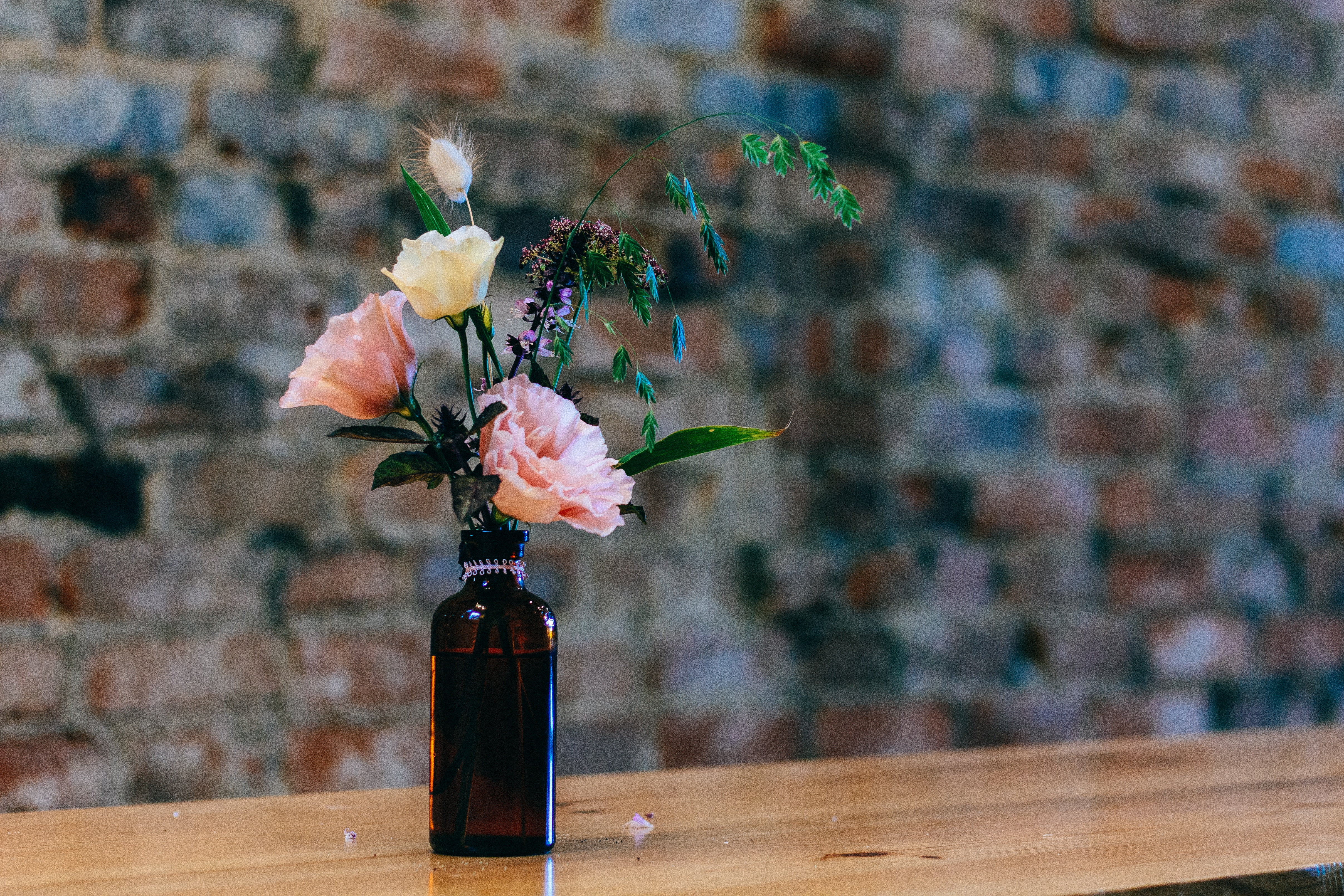 black glass bottle and petaled flowers