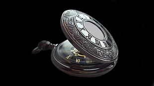 silver pocket watch opened with black background