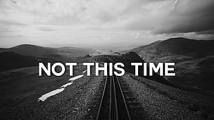 train rail with not this time text overlay, mountains, black, text, monochrome