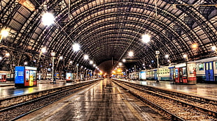 gray steel railway inside train station surrounded by assorted lights