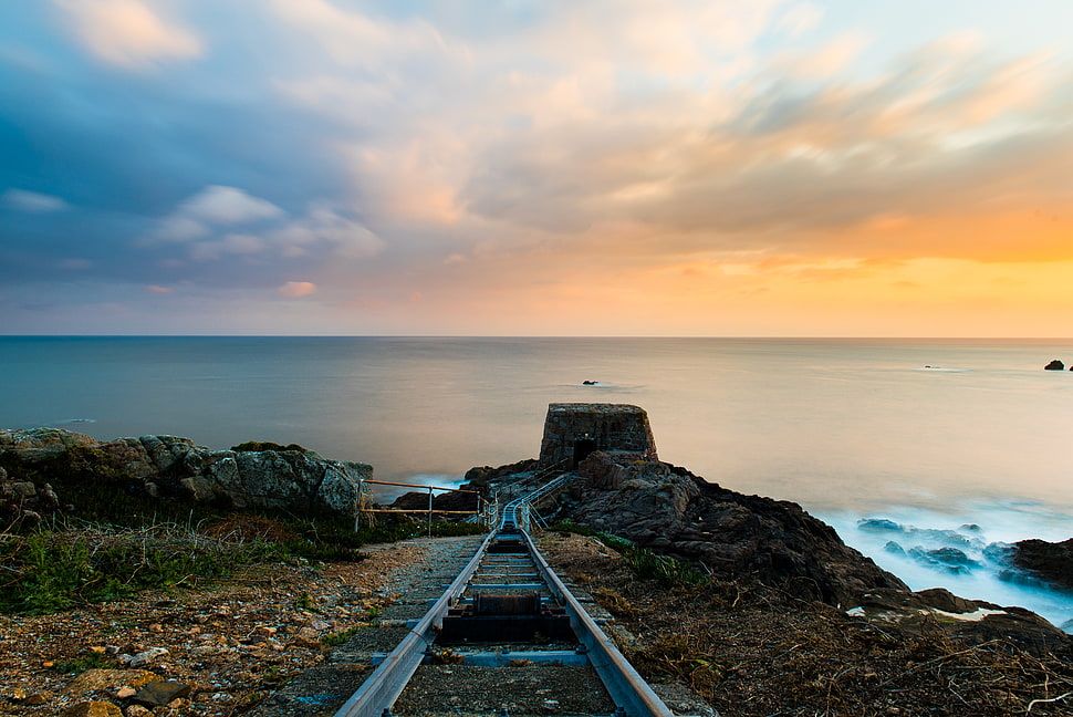 train rail view near on ocean during day time HD wallpaper
