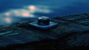 depth of field photography of metal nut on top of black surface