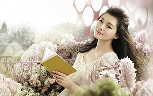 woman wearing white scoop-neck top holding book