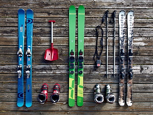 three pairs of ski blades with bindings and ski poles