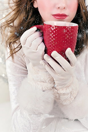 woman in white gloves holding white ceramic coffee mug
