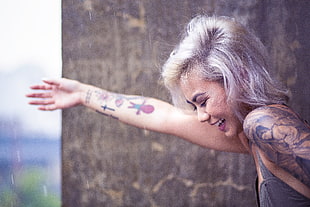 woman with many Tattoos spreading her arms