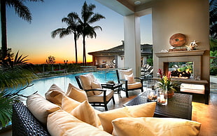beige couch set beside below-ground swimming pool during sunset