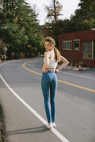 woman in white crop top and blue jeans
