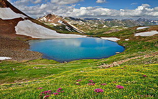 photo of lake surrounded by mountain ranges and plants during daytime HD wallpaper