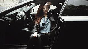 woman in brown jacket sitting inside black car HD wallpaper