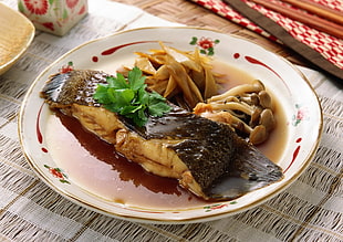 cooked fish served on round white ceramic plate