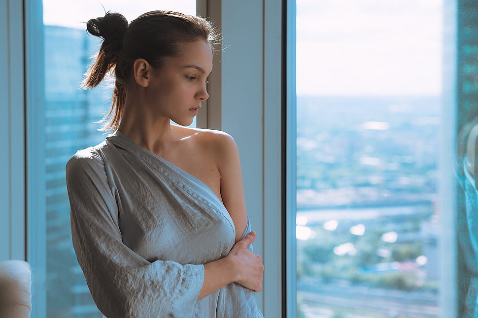 woman in grey top standing near window during daytime HD wallpaper