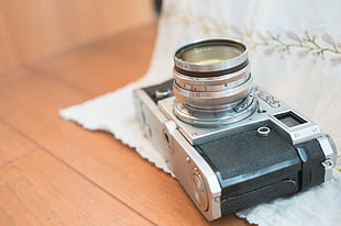 black-gray digital SLR camera on white textile, kiev