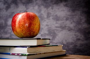 red apple on books