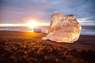 crystal stone fragment on seashore during sunset in tilt shift lens photography