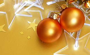 closeup photo of two orange baubles near clear glass stars