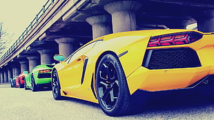 four assorted-colors of Lamborghini Aventadors parked on roadside