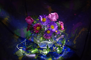 purple, pink and yellow flowers top of blue textile