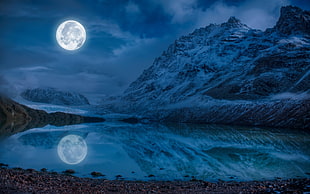 snowy mountains during night with full moon