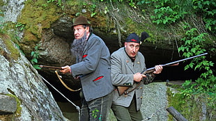 two man holding rifle