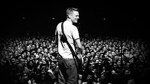 man playing guitar in front of crowd