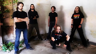 group of five men wearing black shirts near wall