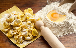 photo of dumplings beside flour with egg and rolling pin