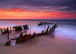 wrecked ship on beach during sunset, qld