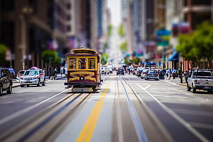 yellow tram traveling on road focus photography
