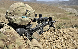 soldier holding black sniper rifle during daytime
