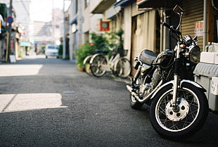 black cruiser motorcycle beside gray building