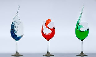 photography of clear wine glasses filled with assorted colored liquids