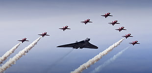 red and black planes flying and forming triangle shape